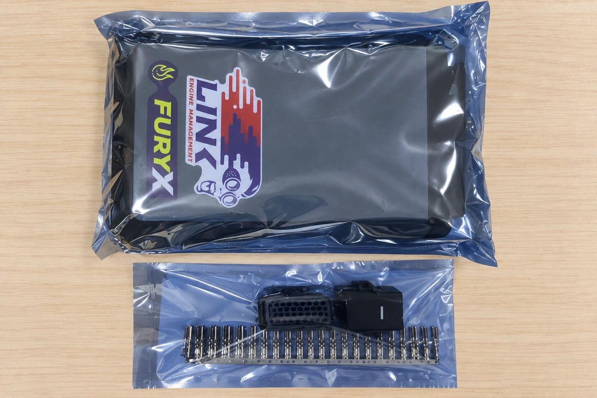 LINK FuryX ECU in protective packaging beside connector housings and terminals
